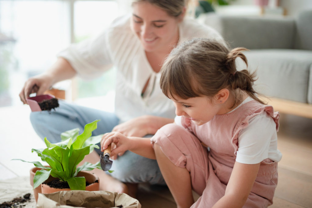 mother and daughter replant a flower